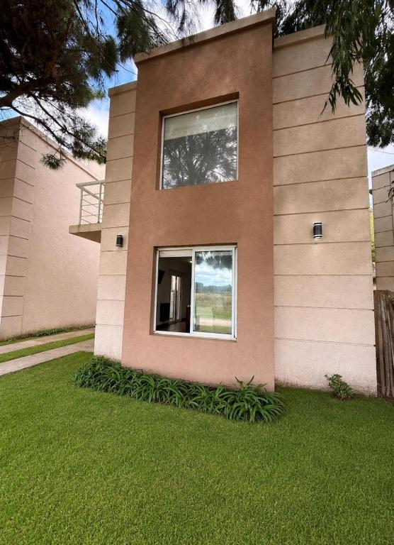 a house with a window on the side of it at Cabañas Aires del Bosque in Santa Teresita
