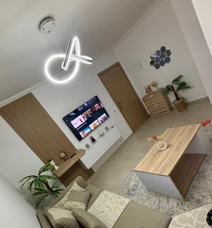 a living room with a table and a tv at Résidence Calme Fnideq in Fnidek