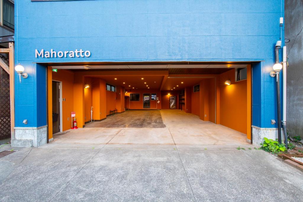 a blue and orange building with a parking lot at mahoratto in Aomori