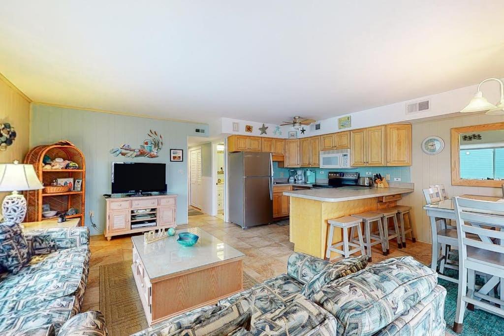 a living room with a couch and a kitchen at Surfs Up 301 in Ocean City