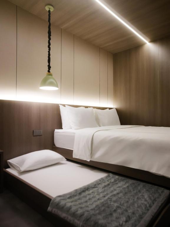 a bedroom with two beds and a pendant light at Singgah Ijen in Biau
