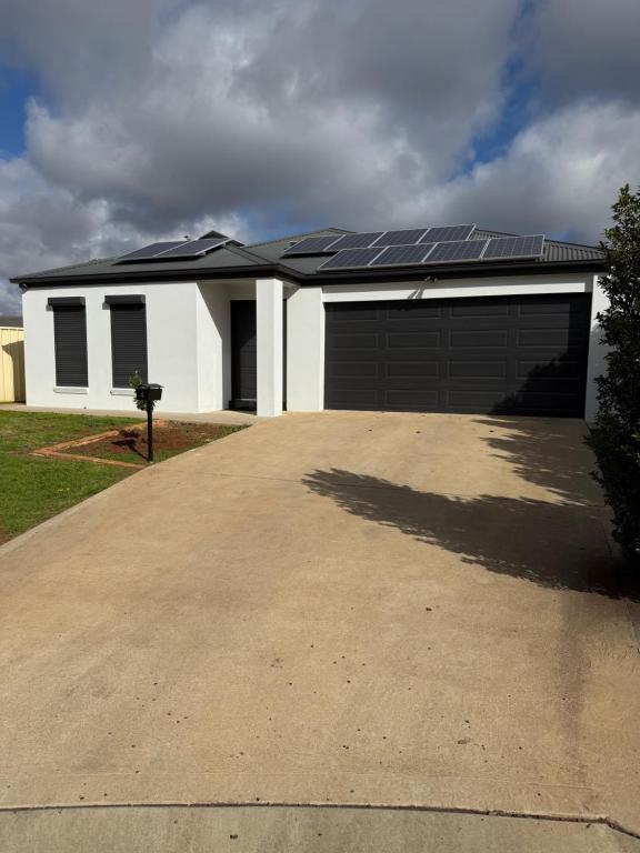 a house with a garage with solar panels on it at The Holiday Home Griffith in Griffith