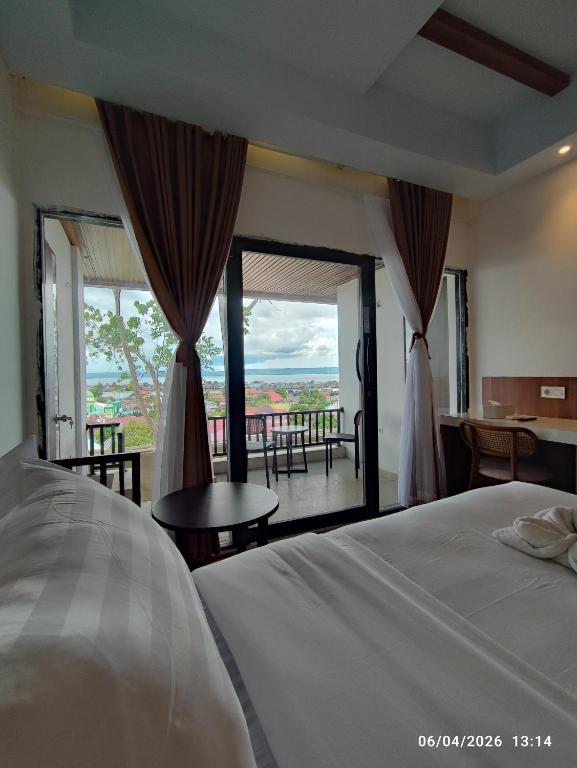 a bedroom with a bed and a view of a balcony at Wisma SIDAPORE JD in Lamobuang