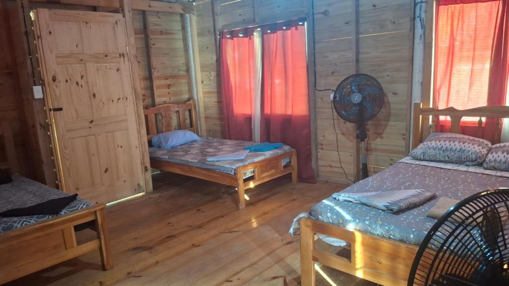 a room with two beds in a wooden cabin at Cabañas con baño Privado in Soledad Miriá Ubigantupo