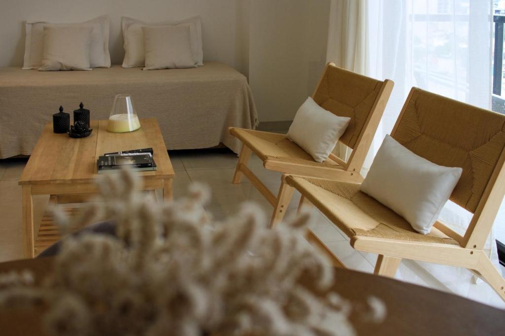 a room with a bed and two chairs and a table at Capibara 4 - Imponente vista al Río in Corrientes