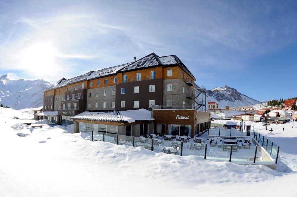 un gran edificio en la nieve en las montañas en Virgo Hotel & Spa en Las Lenas