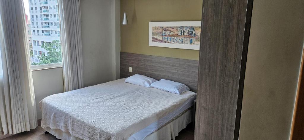 a small bedroom with a bed and a window at Alugo Suite 303 No Mont Blanc in Nova Iguaçu