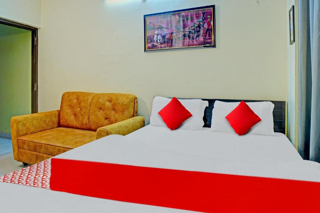 a bedroom with a large bed and a chair at Super Hotel O New View in Bankipur