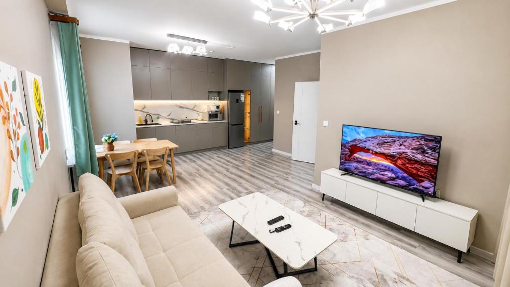 a living room with a couch and a flat screen tv at Stylish Cozy Apartment in UB in Ulaanbaatar