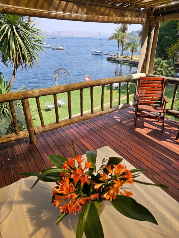 a vase of orange flowers on a table on a deck at Woodpecker cottage in Hartbeespoort