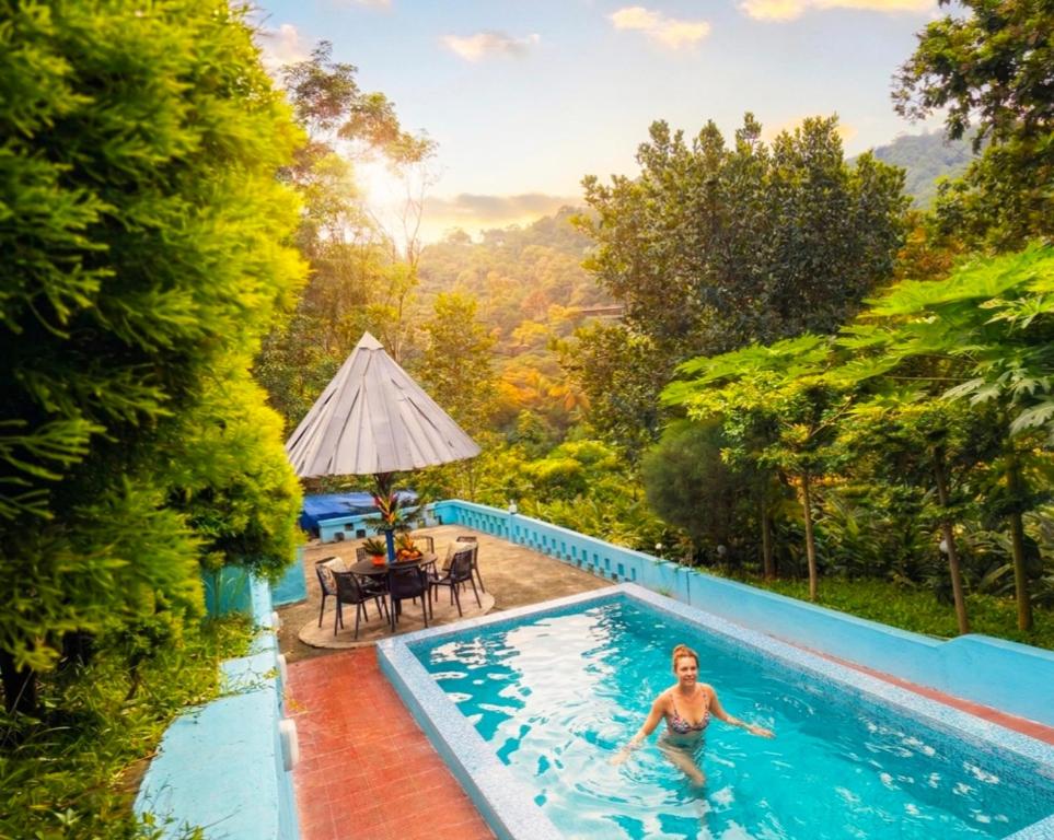 a man in the swimming pool of a villa at Misty valley Private Pool Villa Munnar in Anachal