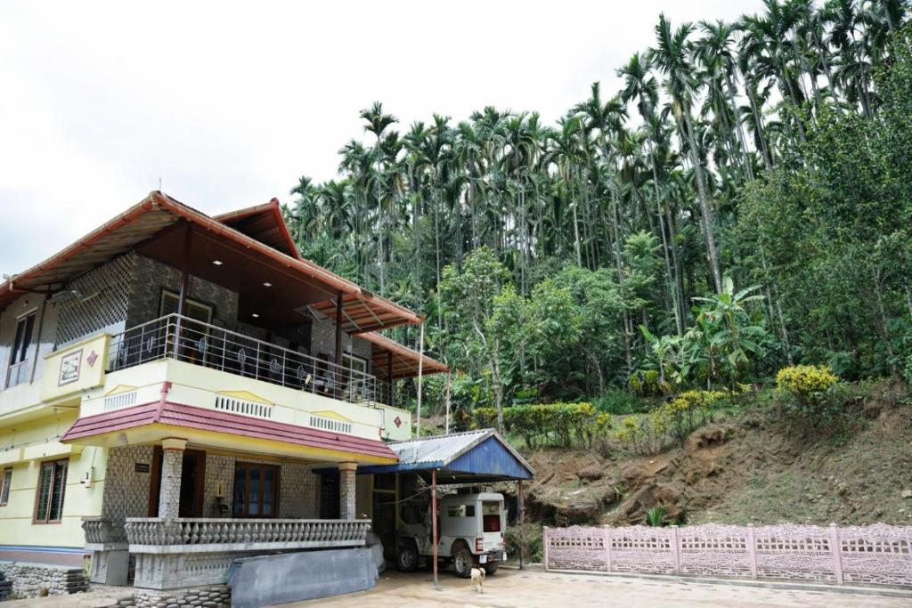 a house with a truck parked in front of it at Peak Homestay in Kalasa
