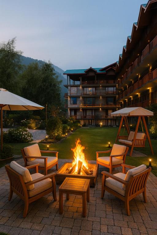a group of chairs and a fire pit in front of a hotel at Himalayan Fort Resort, Manali - A Riverside Retreat in Manāli