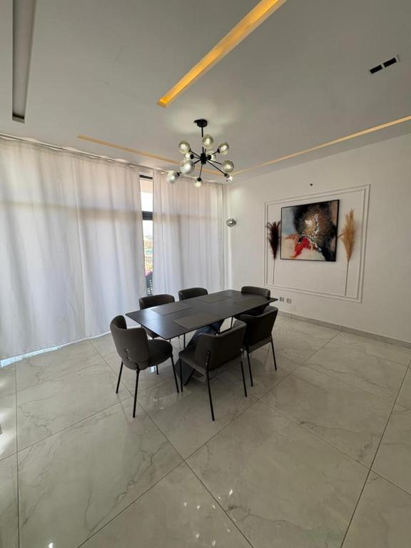 a dining room with a black table and chairs at Appartement 2 chambres in Cotonou