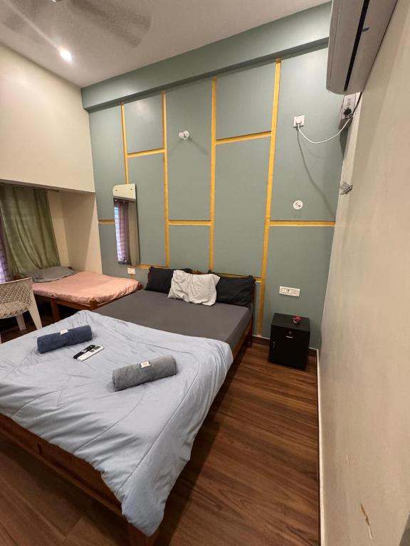 a bedroom with a bed with two pillows on it at Golden Waves Guest House in Mahabalipuram