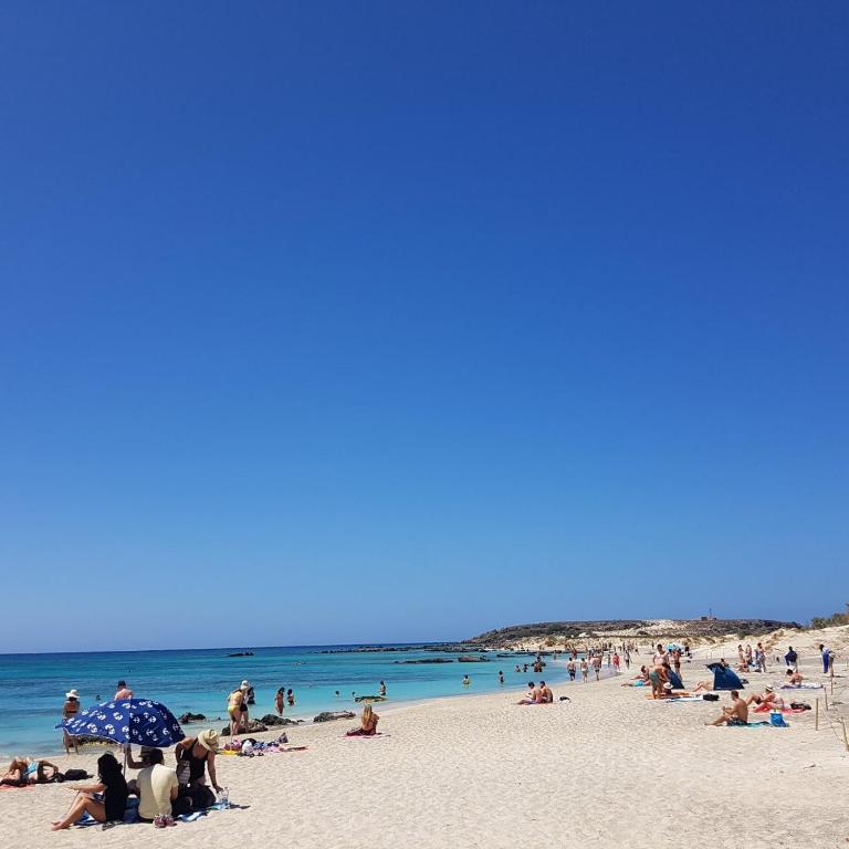 a group of people on a beach with the ocean at Villa Joanna Seasides , Top Floor in Mesimérion