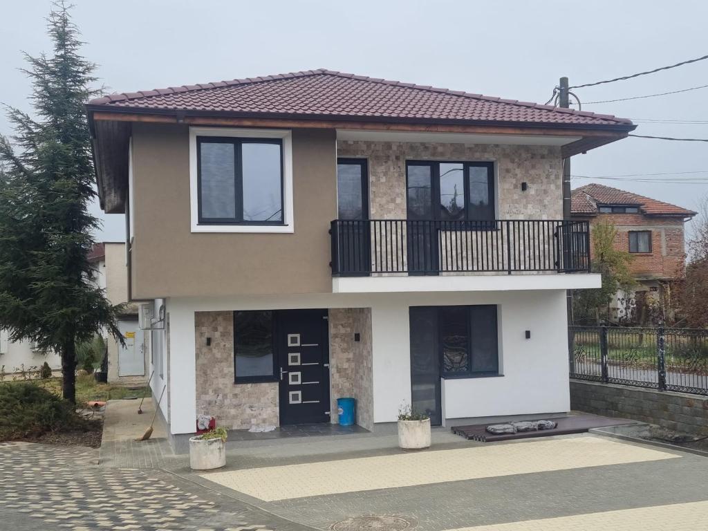 a house with a balcony on a street at Complex Trakite in Elkhovo