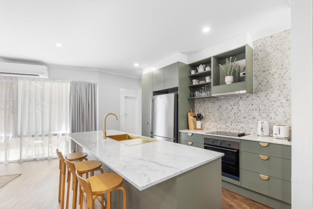 a kitchen with green cabinets and a counter top at 3 Bedroom City Apt, Big Yard & Park Views - Sleeps 7 in Adelaide