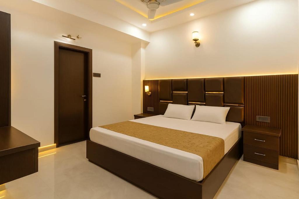 a bedroom with a large bed with a wooden headboard at Hotel Empress Gold in Agra