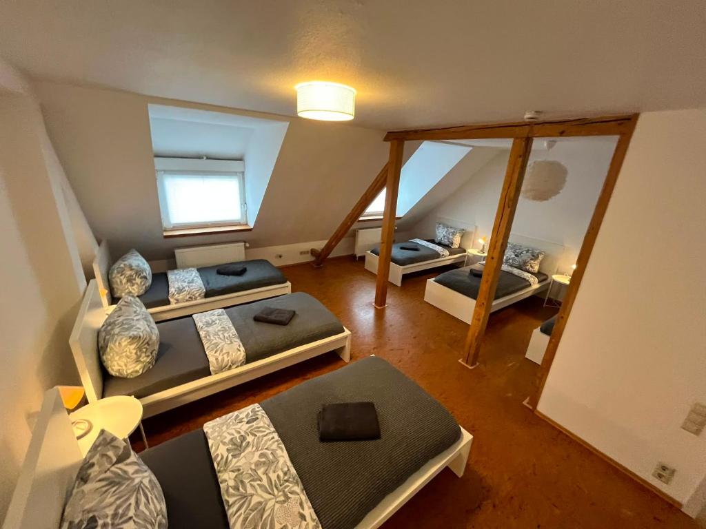 an attic room with three beds and a mirror at Süße Marie 18 - Coffee for free - in Karlsruhe