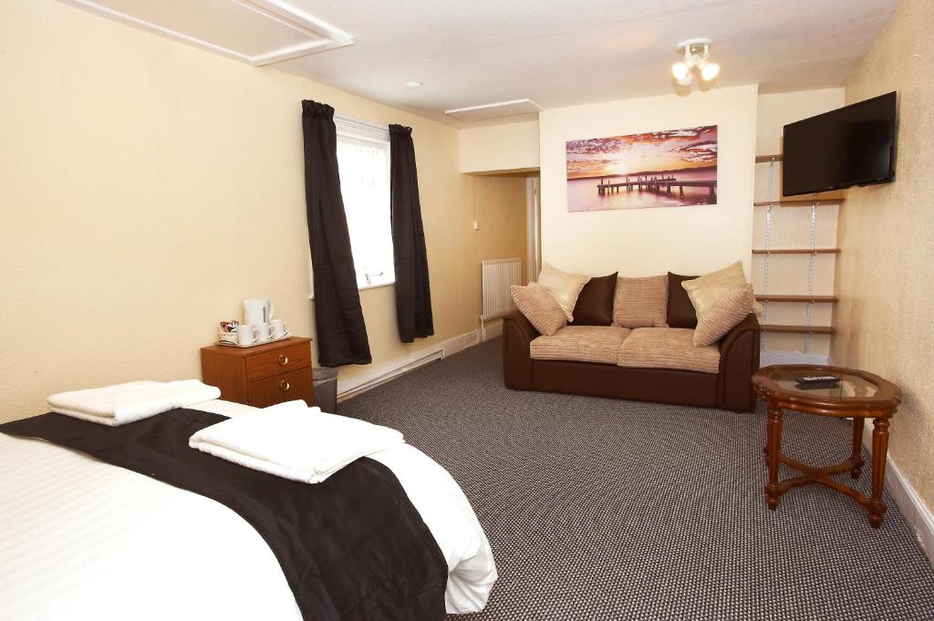 a hotel room with a bed and a couch at The Black Swan Inn in Leominster