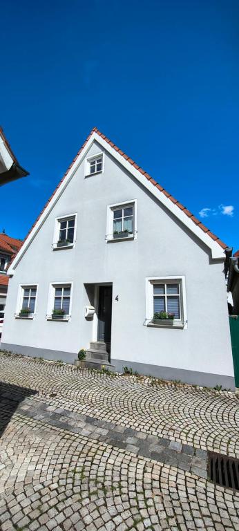 a white house on a cobblestone street at FeWo Altstadt Herrieden in Herrieden