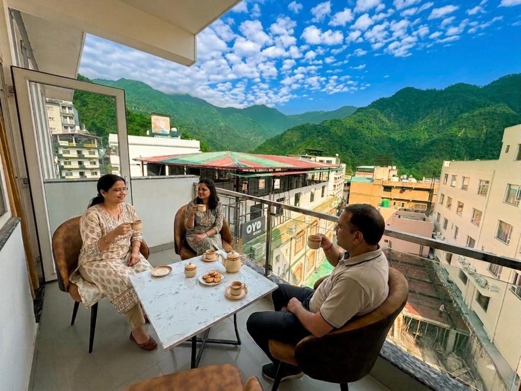a group of people sitting at a table on a balcony at Hotel Mahadev Tapovan in Rishīkesh