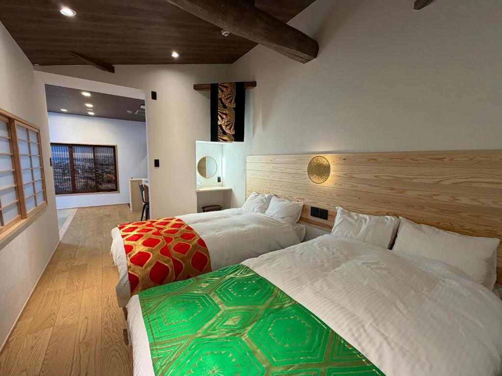 a bedroom with two beds in a room at Besso城前 in Himeji