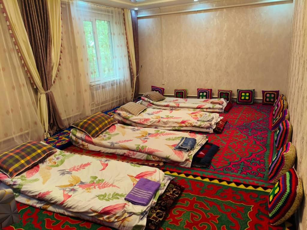 a group of four beds in a room at Oskon Guesthouse in Kyzart