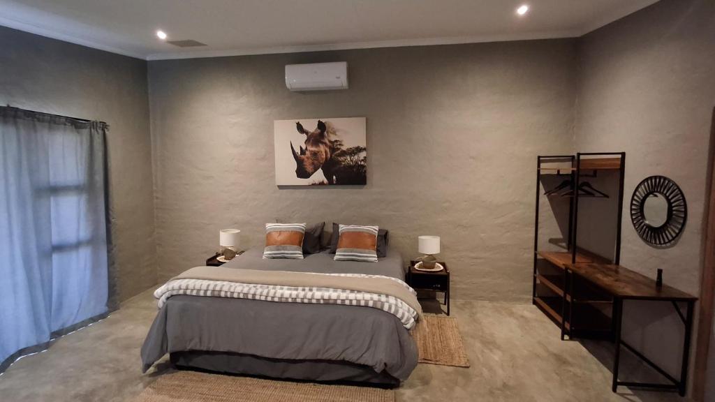 a bedroom with a bed and a picture on the wall at GROOTVALLEI SELF CATERING Units in Mahikeng
