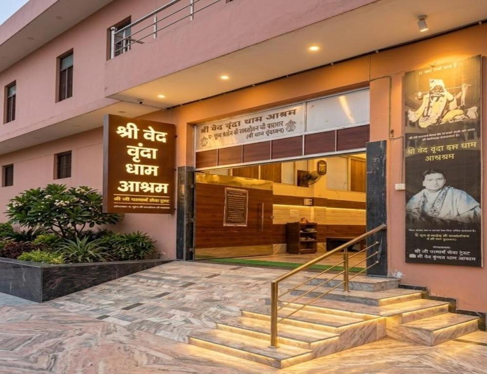 a building with stairs in front of a store at Shri Ved Vrinda Dham Aashram in Chhatikara