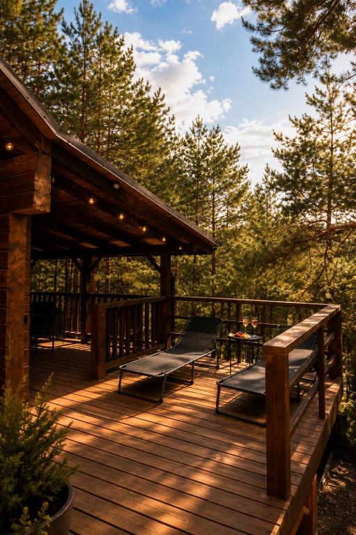 a wooden deck with two benches and a table on it at Nice House in Maidan Village