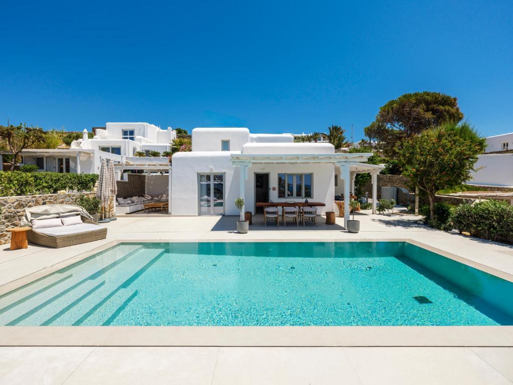 a villa with a swimming pool in front of a house at myMykonos Villa I in Platis Gialos