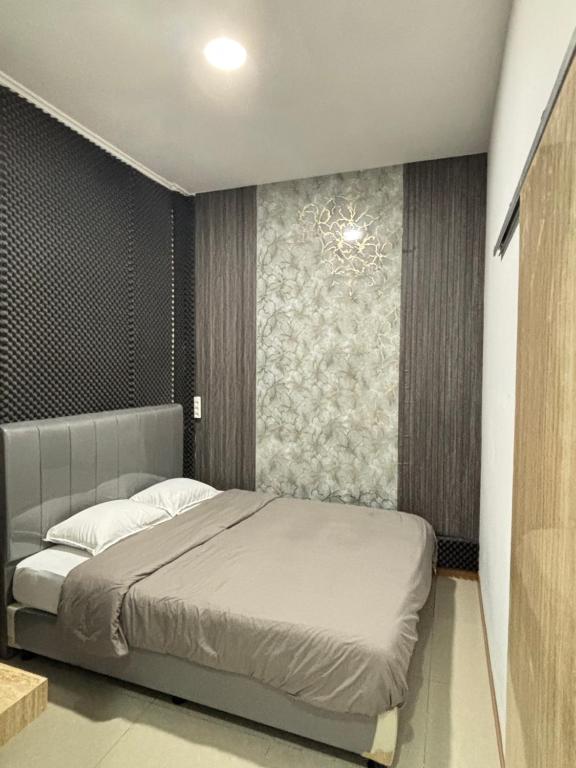 a bedroom with a bed and a wall at Lovisya Residence in Jakarta