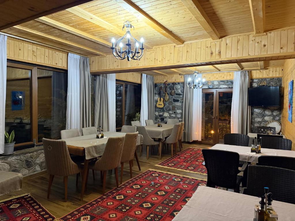 a restaurant with tables and chairs and a chandelier at Guesthouse Demushi in Valbonë