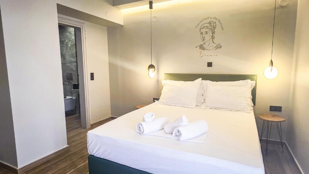 a bedroom with a bed with towels on it at Costa Mare Rooms in Paralia Katerinis