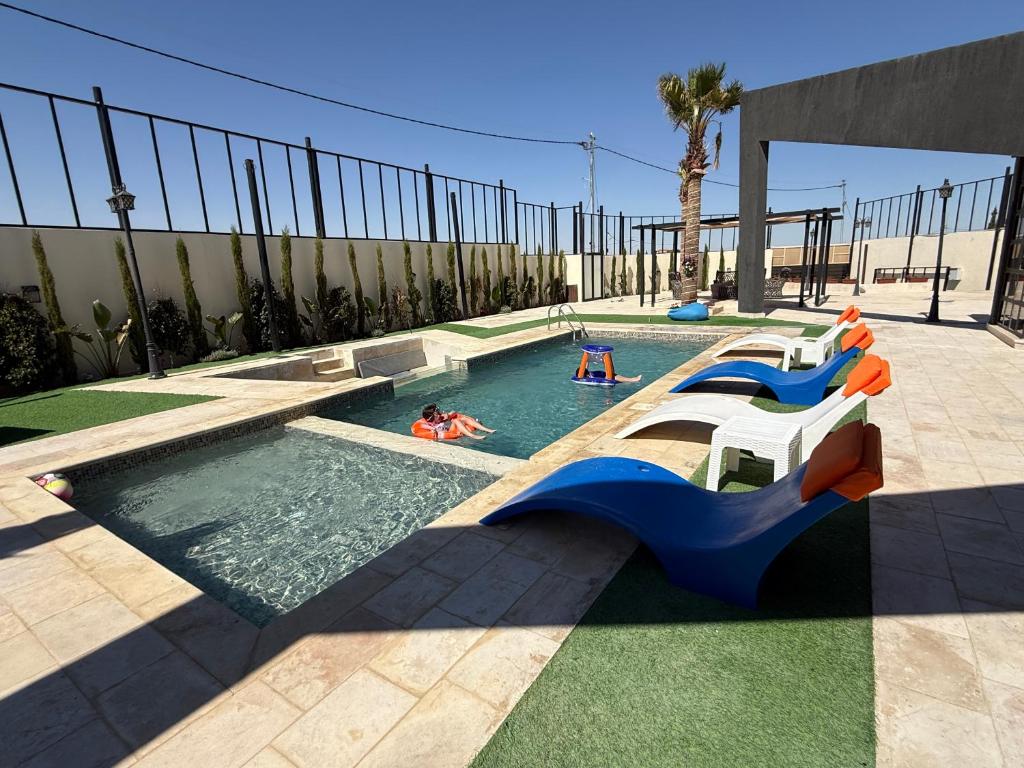 a pool with a slide and people in the water at Giving Vibes Chalet in Amman
