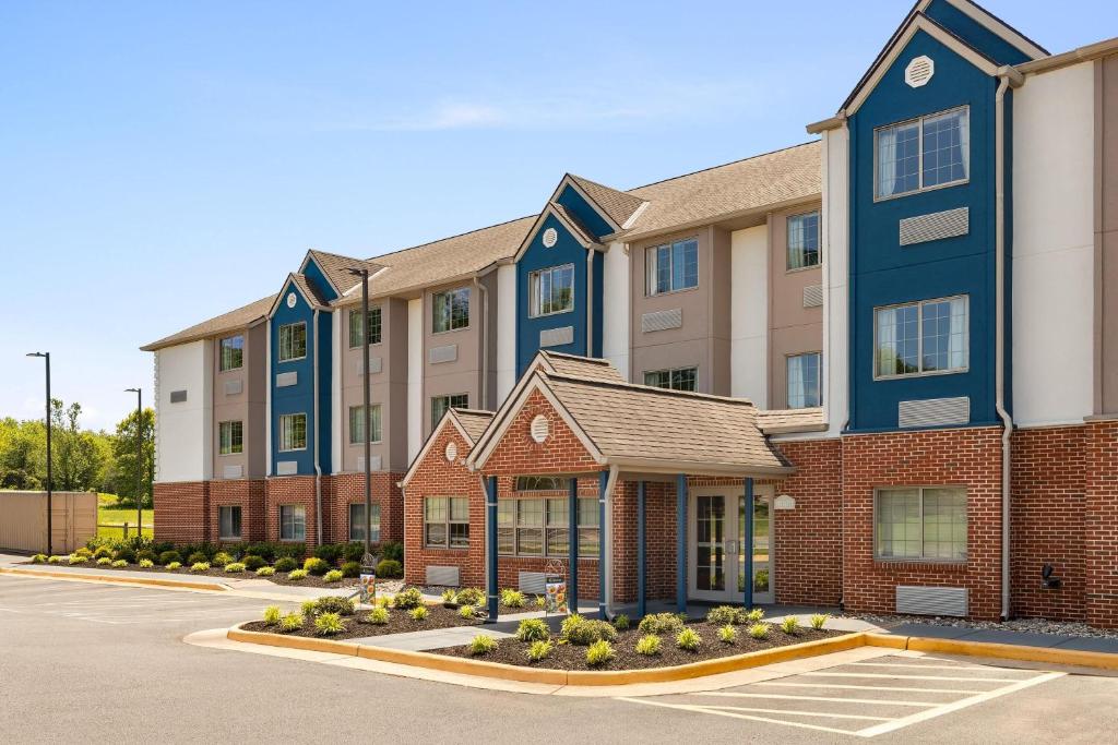 an apartment building with a parking lot at Microtel Inn & Suites by Wyndham Culpeper in Culpeper