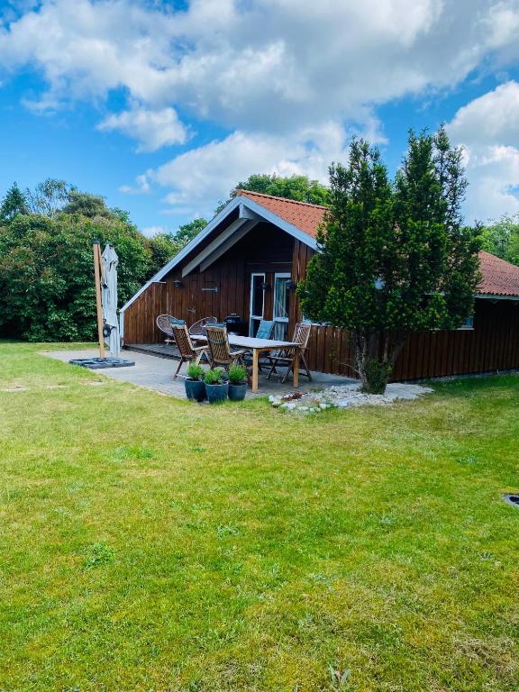 a cabin with a table and chairs in the yard at Huset ved stranden in Nykøbing Sjælland