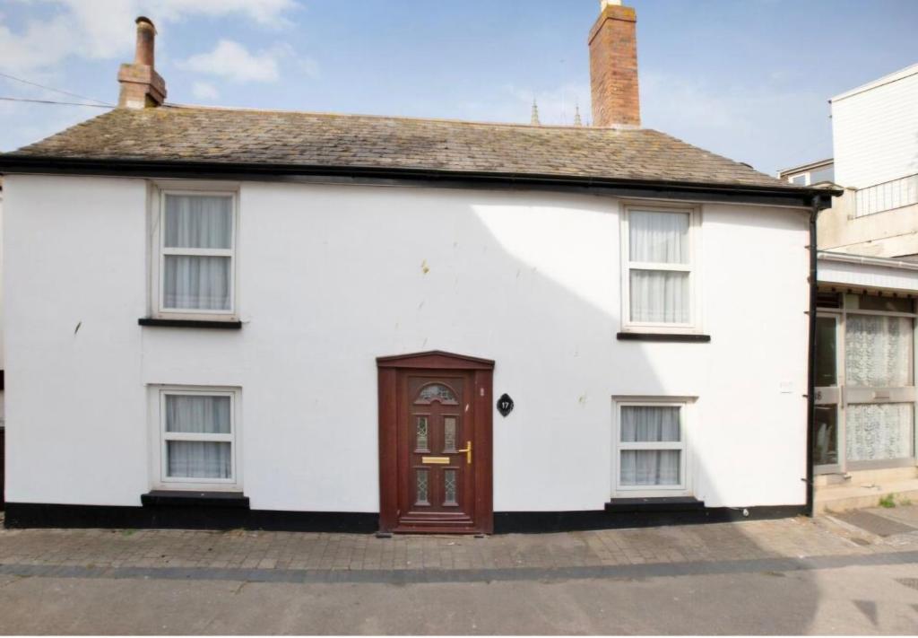 a white house with a brown door at 17 French Street in Teignmouth
