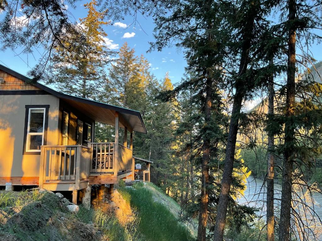 a house in the woods with a porch at Doug's Emporium and Riverside Cabins in Hedley