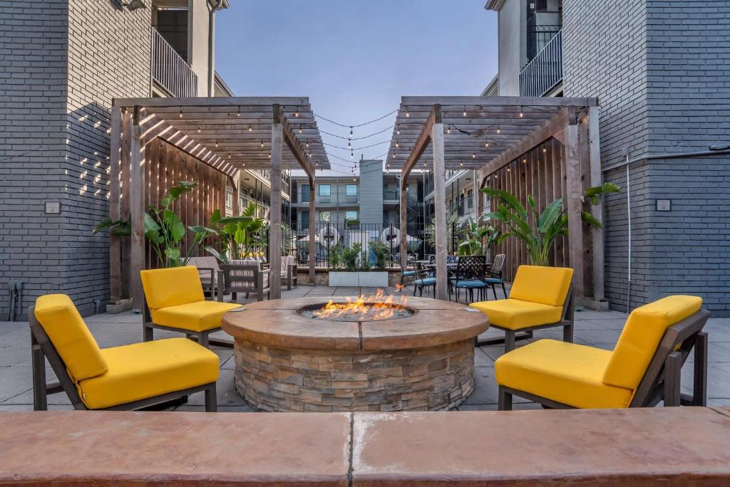 a patio with yellow chairs and a fire pit at Country Inn & Suites by Radisson, Metairie New Orleans , LA in Metairie