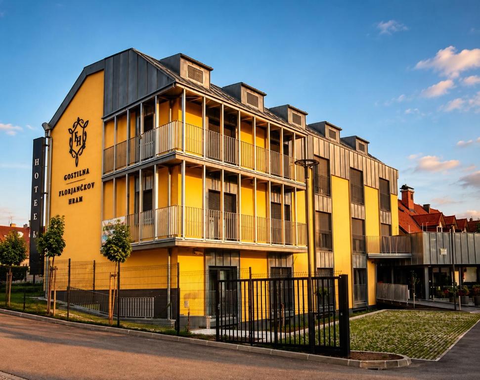 a yellow building with a black roof on a street at Hotel Florjančkov Hram in Ljubljana