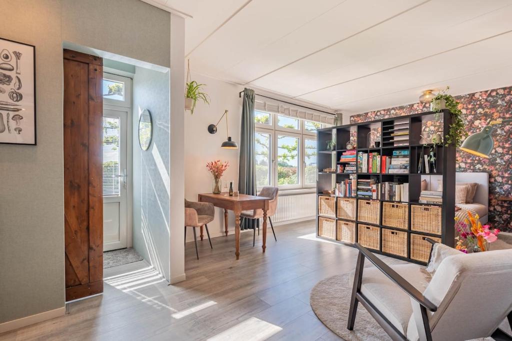 a living room with a table and a book shelf at Hoeve Hunzedal in Eexterzandvoort