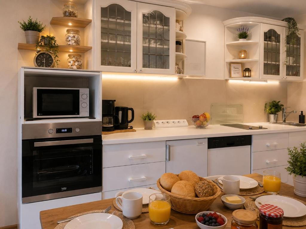 a kitchen with white cabinets and a table with food at Ferienwohnung Möwe in Schönberg