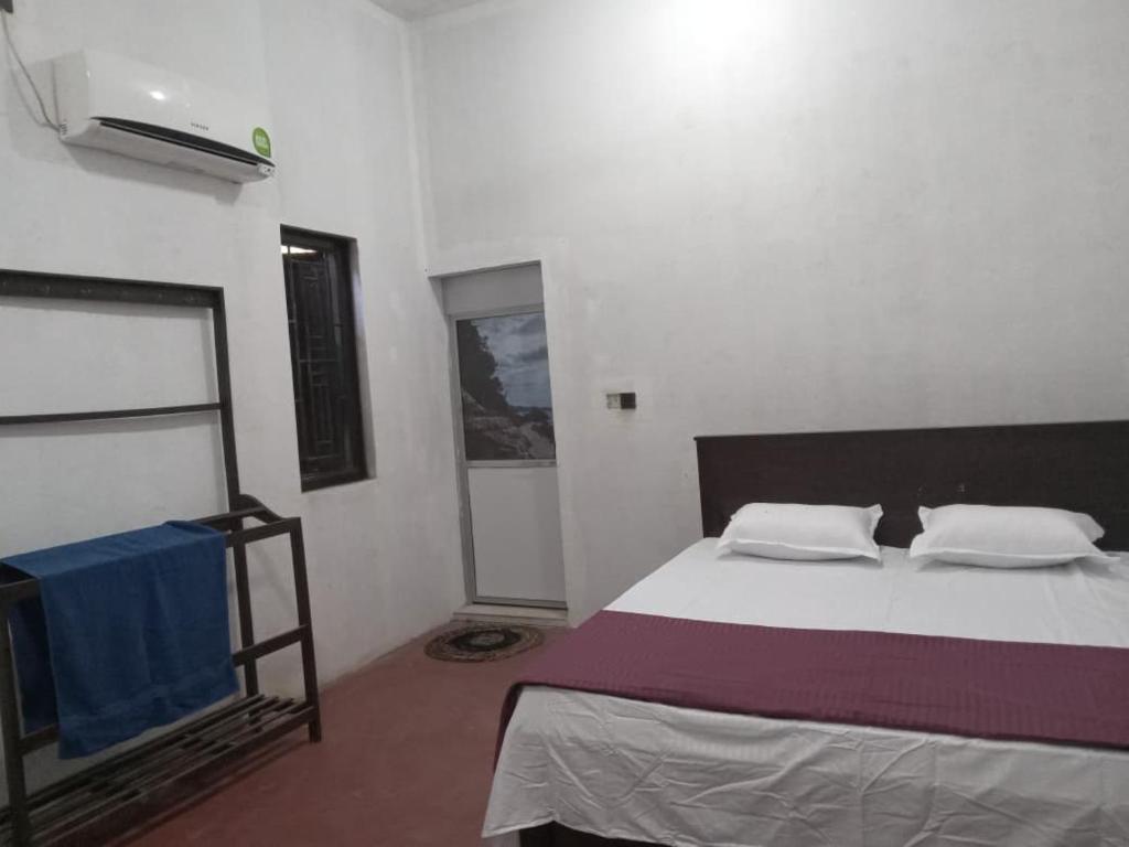 a bedroom with a large bed and a fireplace at Breezy Villa - Arugambay in Arugam Bay