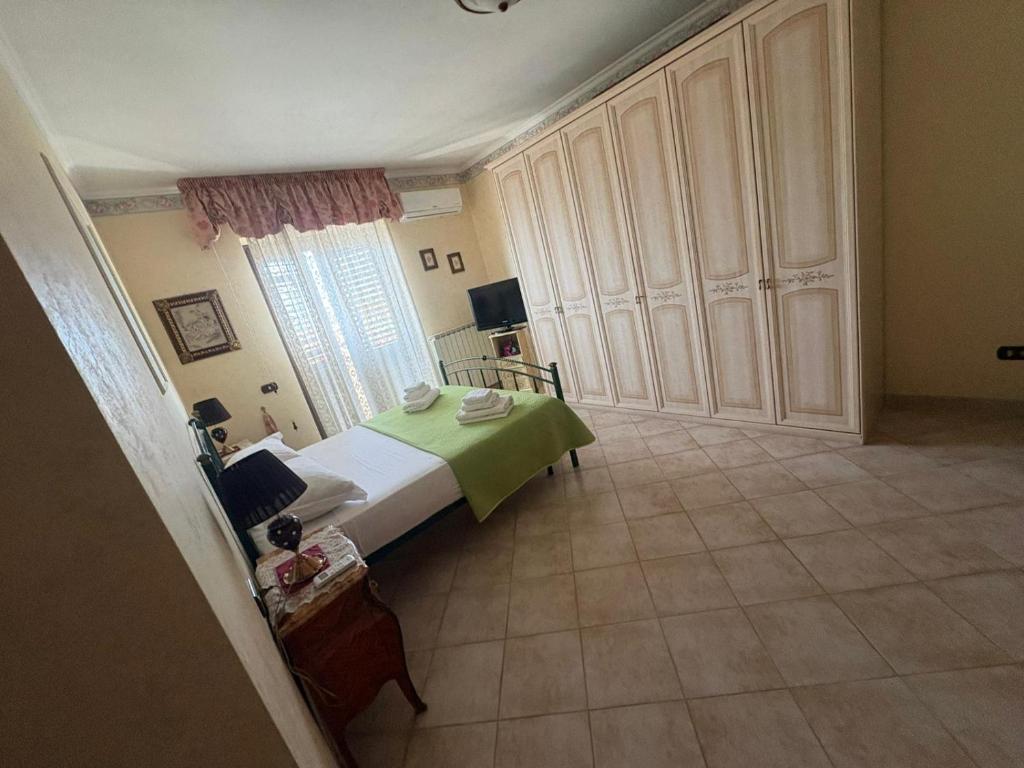 a bedroom with a bed with a green blanket at Fiumicino River in Fiumicino