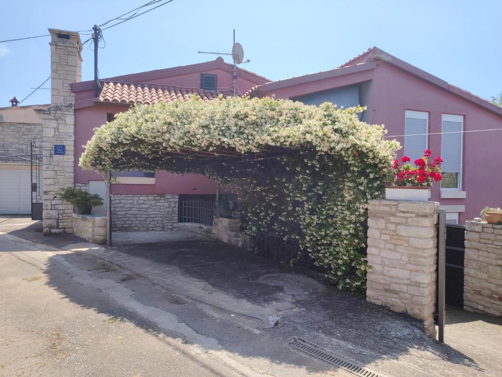 a house with an ivy covered entrance to a driveway at Gorgeous Apartment Garma in Kavran