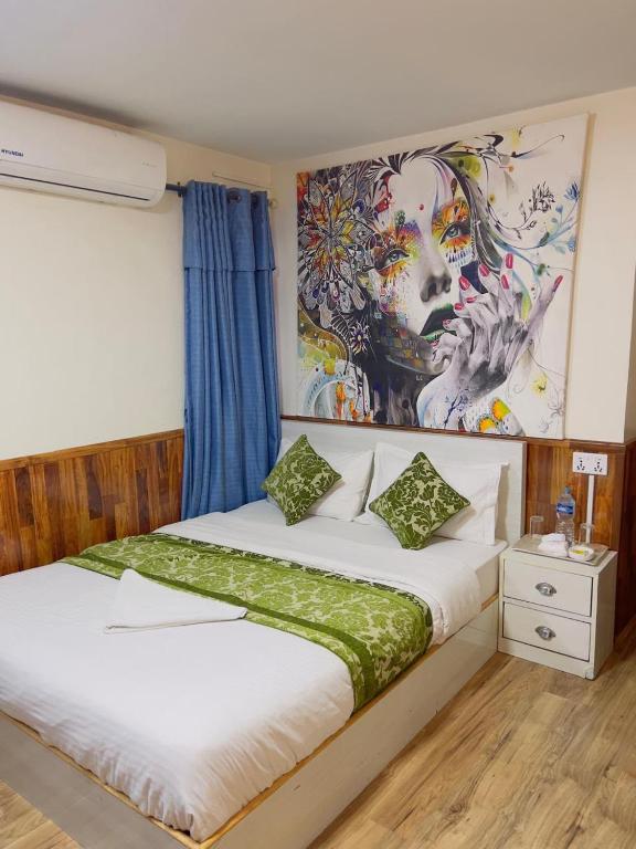 a bedroom with a bed with a painting on the wall at Hotel Mirana Pvt Ltd in Kathmandu
