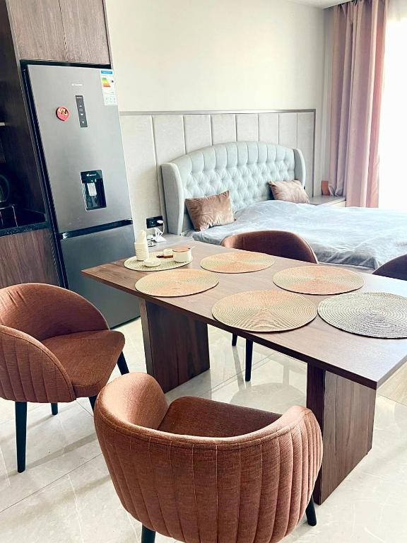 a room with a table and chairs and a bed at SeaBreeze Resort Baku Apartment Studio in Baku